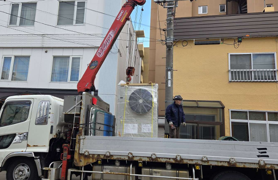 クレーン車によるGHP室外機の搬入（小樽市 飲食店）