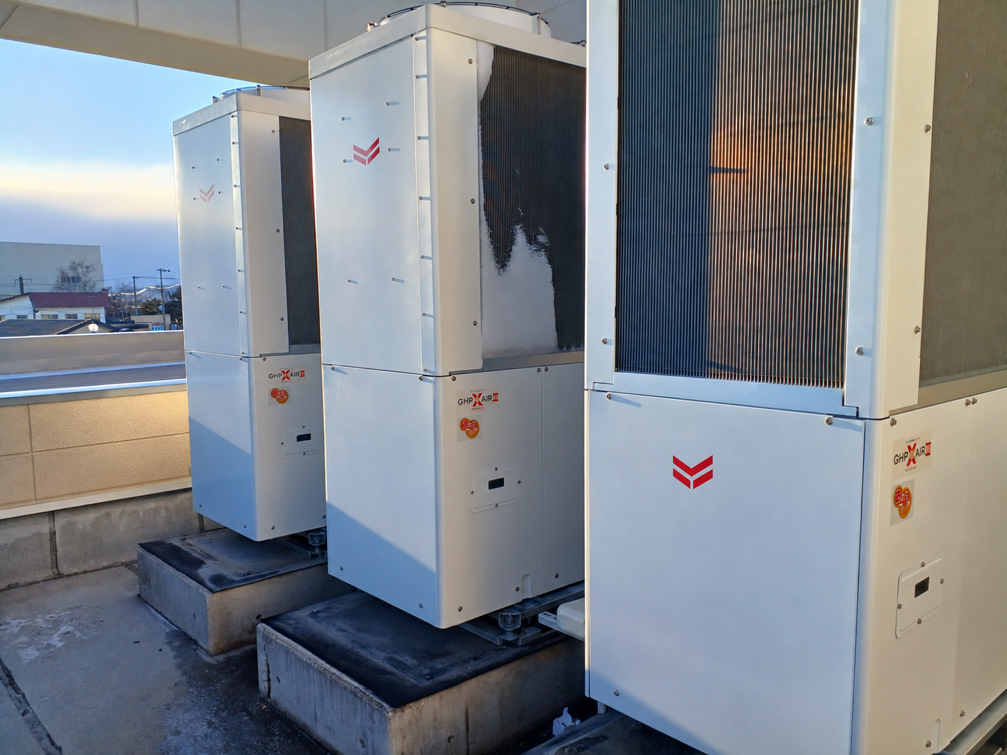 更新後の屋上に並ぶ新しいGHP室外機